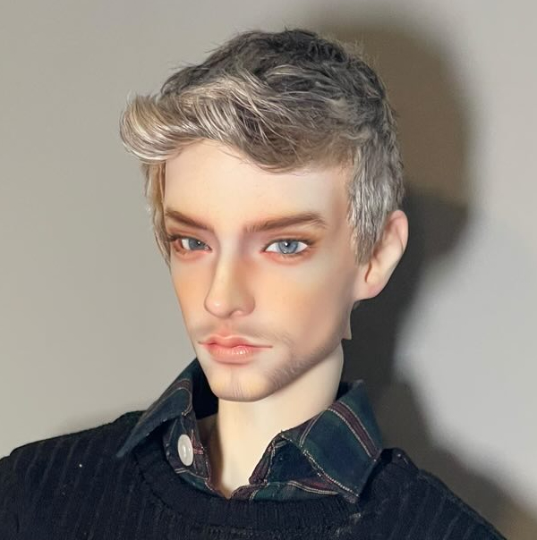 A male doll with ash blond hair