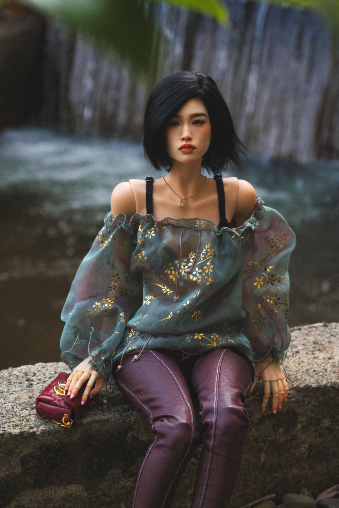 A female asian doll with deep red lips wearing a red head scarf