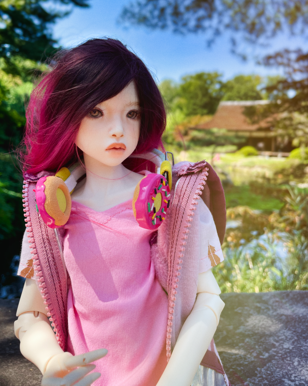 A child female doll with red and black hair wearing a white cable knit sweater